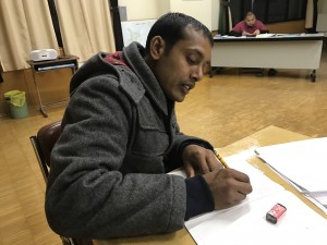 修了式のスピーチを書くラザックさん