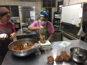 キムチのパッキングの指導をしてくださる平井さん(キムチの作り方は四国支部のチェさんが教えてくれました)